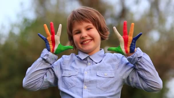 Grabben leker måla regnbågshänder. Glada liten flicka visa hej gest med händerna målade i Seychellerna flaggan färger. — Stockvideo