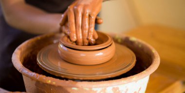 Çömlekçi adam kil kaplama ile çalışır. Doğa geçmişi olan genç bir çömlekçi.