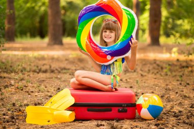 Tutkulu küçük kız mayo, yüzgeç ve yüzme maskesiyle yaz tatili için bavullarını topladı.
