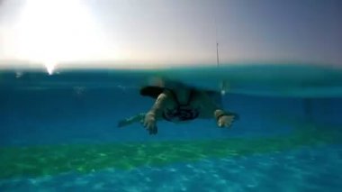 Yaz tatili boyunca havuzda yüzen genç bir kadının su altında çekilmiş görüntüleri.