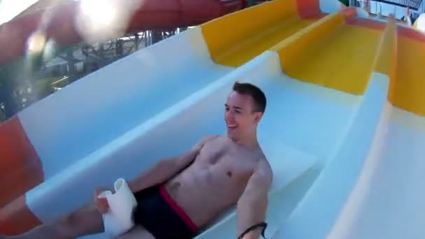 Man having fun in swimming pool. Happy cheerful male on holiday resort. Summer vacation enjoy on waterslide. Funny ride on water slide pool in water park. Sliding down In waterpark. — Stock Video