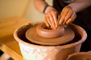 Çömlekçi adam kil kaplama ile çalışır. Doğa geçmişi olan genç bir çömlekçi.
