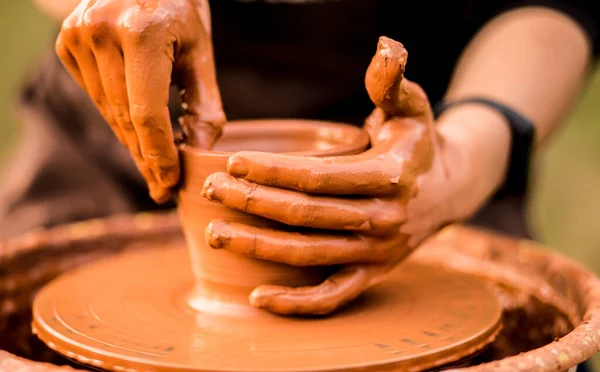 Руки гончара сделать керамическую банку на гончарном круге на открытом воздухе — стоковое фото