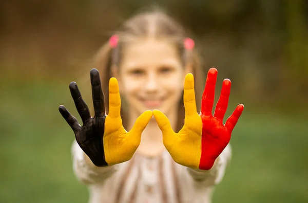 Детские руки девушки окрашены в цвета флага Бельгии, сосредоточиться на руках — стоковое фото