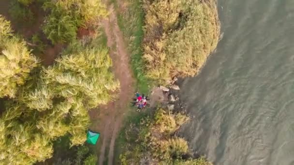 Flyg topp ner drönare syn på grupp människor som ligger på gräs som stjärna, vänner har god tid tillsammans utomhus i vår park nära sjön — Stockvideo