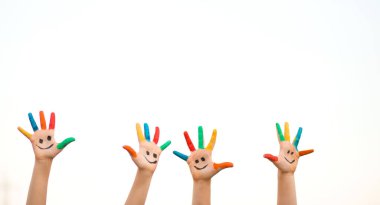 Renkli boyalı elleri ve beyaz tenli komik gülüşü olan çocukların afiş görüntüsü