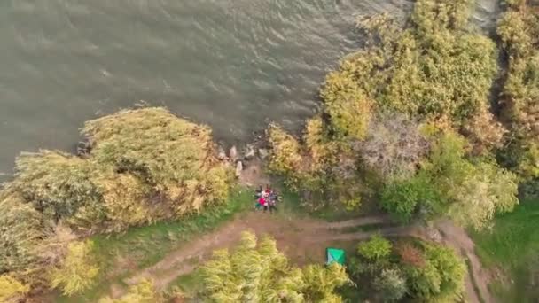 Aerial top down drone view of group people lying on grass like star, friends have good time together outdoor in spring park near lake — Stock Video