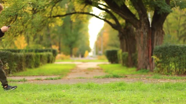 Telefoon verslaafde kinderen vriend meisjes groep lopen samen in de zomer park en het spelen van internet spel met mobiele smartphone. Kinderen sms 'en via de telefoon buiten in de zomertuin. Levensstijl van bloggers — Stockvideo