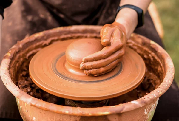 Крупный план человека, работающего на гончарном круге и делающего глиняный горшок открытым — стоковое фото