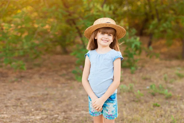 Menina adorável criança em chapéu de palha passar o tempo ao ar livre no dia de verão. Retrato feliz de criança sorrindo tímida — Fotografia de Stock