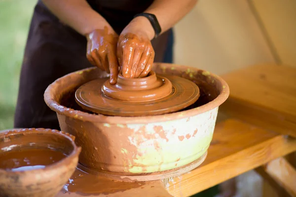 Руки гончара делают посуду из керамики на гончарном круге. Скульптор в цехе производит глиняный продукт — стоковое фото
