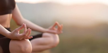 Gün doğumunda yoga nilüferinde oturmuş denge için meditasyon yapan kadınların seçici elleriyle yakın çekim yapın. Kopya alanı olan web sitesi başlık tasarımı için yatay pankart görünümü 
