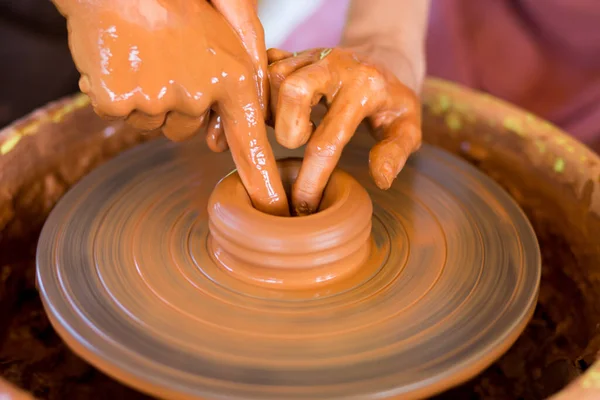 Clase magistral para niños. Las manos maestras enseñan al chiquitín, cómo hacer los platos de cerámica sobre el volante de alfarero. Artista trabaja con arcilla. Niña esculpir taza de arcilla —  Fotos de Stock