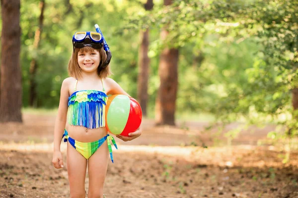 Criança feliz em máscara de snorkel e roupa de mergulho para mergulho debaixo d 'água segurar bola de jogo. Vida de viagem em família no acampamento de aventura de verão. Atividades de natação na praia crianças de férias — Fotografia de Stock