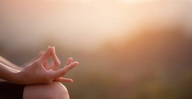 Gün doğumunda yoga nilüferinde oturmuş denge için meditasyon yapan kadınların seçici elleriyle yakın çekim yapın. Kopya alanı olan web sitesi başlık tasarımı için yatay pankart görünümü 