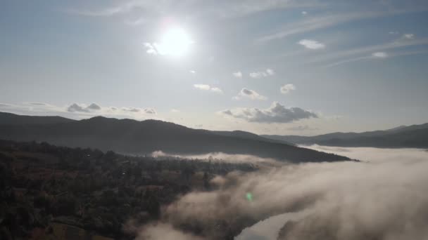 Flygdrönare flygvy över låga moln och morgon dimma täckta bergssluttningar vid soluppgången. Soluppgång i bergen moln. — Stockvideo