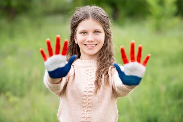 Croatia flag painted on child hands. Girl with open hands raised. Patriotic holiday. Independence Day, 25 June. Croatia Independence Day concept. Victory and Homeland Thanksgiving Day, 5 August, 15