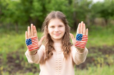 Amerikan bayrağı renginde boyalı elleri olan sevimli küçük kız çocuğu, ellerine odaklan. ABD 4 Temmuz 'u kutluyor. Bağımsızlık Günü 