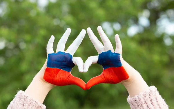 Les mains des enfants peintes dans la couleur du drapeau russe montrent le symbole du cœur et du geste d'amour. Forme de coeur des enfants peints à la main en blanc bleu rouge, concept amour enfants. — Photo
