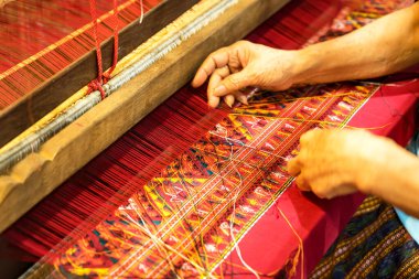 El, ahşap dokuma tezgahındaki kumaşa ipek ipliği yerleştir. Tayland 'da eski bir tekstil işi..