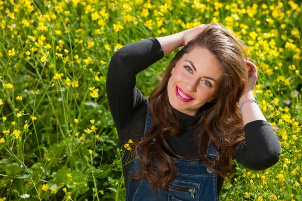 Hermosa joven entre flores amarillas — Foto de Stock