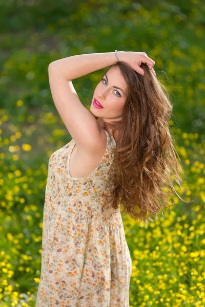 Hermosa joven entre flores amarillas — Foto de Stock