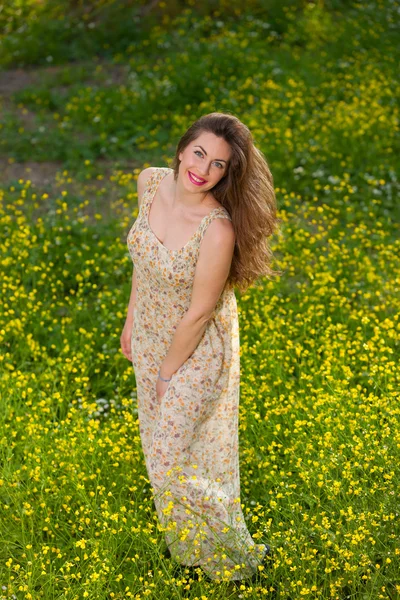 Hermosa joven entre flores amarillas — Foto de Stock