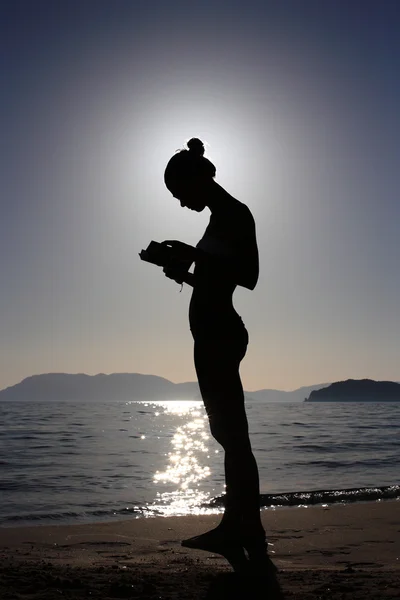 Silhouette di una ragazza con un libro — Foto Stock