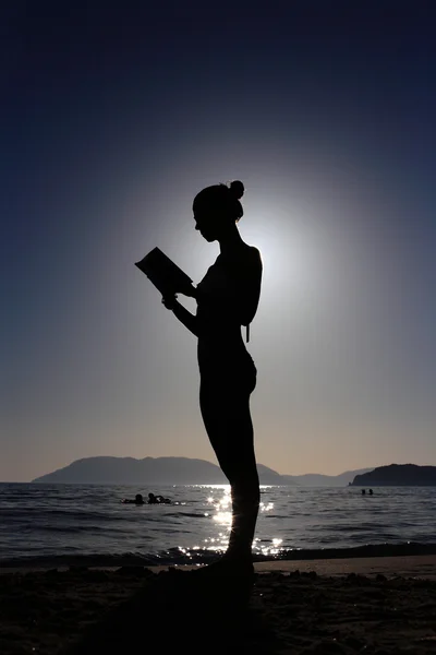 Silhueta de uma menina com um livro — Fotografia de Stock