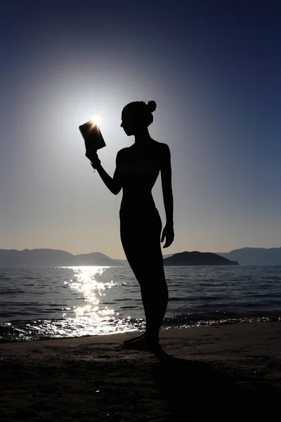Silhouet van een meisje met een boek — Stockfoto