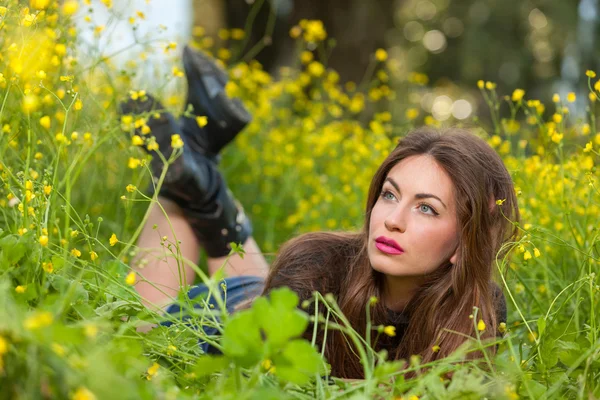 Beautiful young girl among yellow flowers — Stock Photo, Image