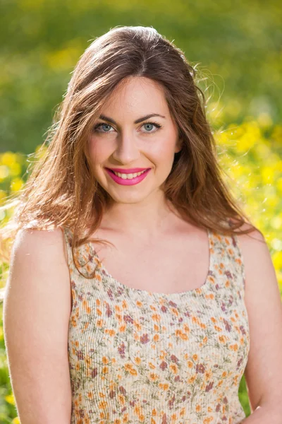 Beautiful young girl among yellow flowers — Stock Photo, Image