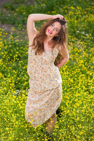 Hermosa joven entre flores amarillas — Foto de Stock