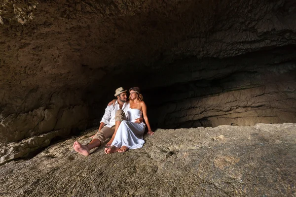 Pareja joven enamorada dentro de una cueva — Foto de Stock