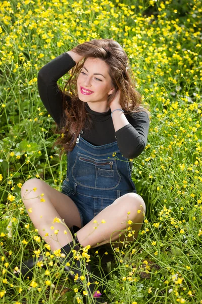 Hermosa joven entre flores amarillas — Foto de Stock