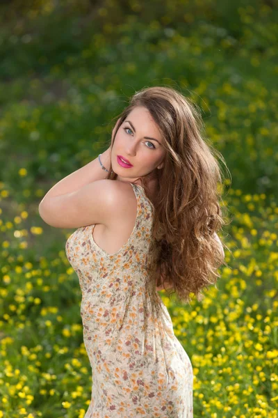 Hermosa joven entre flores amarillas — Foto de Stock