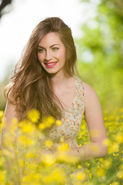 Menina bonita entre flores amarelas — Fotografia de Stock