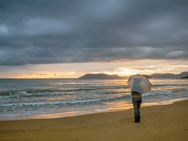 Fille avec parapluie au coucher du soleil — Photo