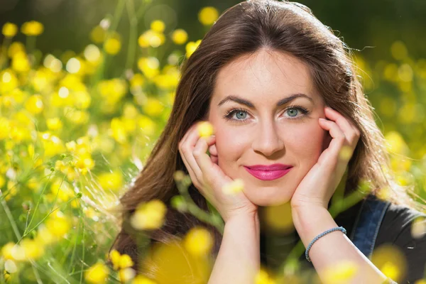 Vacker ung flicka bland gula blommor — Stockfoto