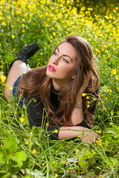 Menina bonita entre flores amarelas — Fotografia de Stock