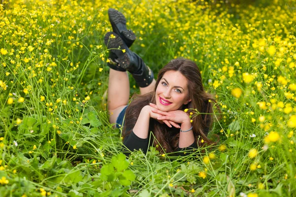 Hermosa joven entre flores amarillas — Foto de Stock