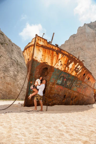 Jeune couple dans une plage avec naufrage — Photo