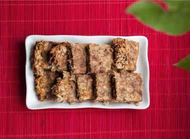 lezzetli yulaf ezmesi kek kare plaka ve pembe bir arka plan ile yaprak yeşil