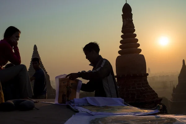 Sand painting vendor shows his products to a traveller — Stock Photo, Image