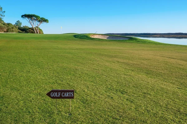 Golfbaan en een teken voor de golfkarretjes. — Stockfoto