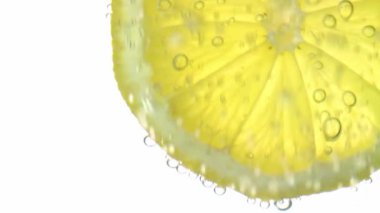 Tazelik kavramı, berrak suda bir dilim limon, ferahlatıcı gaz kabarcıkları, yakın çekim. Citrus içer..