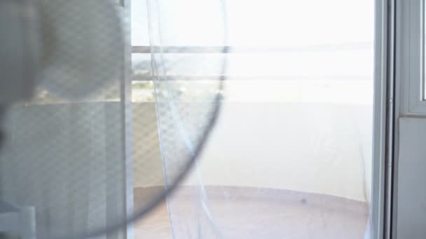 Un ventilateur électrique qui abaisse la température de la pièce donnant sur la véranda. Clé haute. Surexposition. — Video