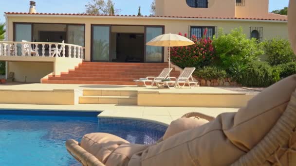 Krásný výhled na bazén s lehátky pro turisty a průzračnou vodou. Luxusní vila pro turisty. — Stock video