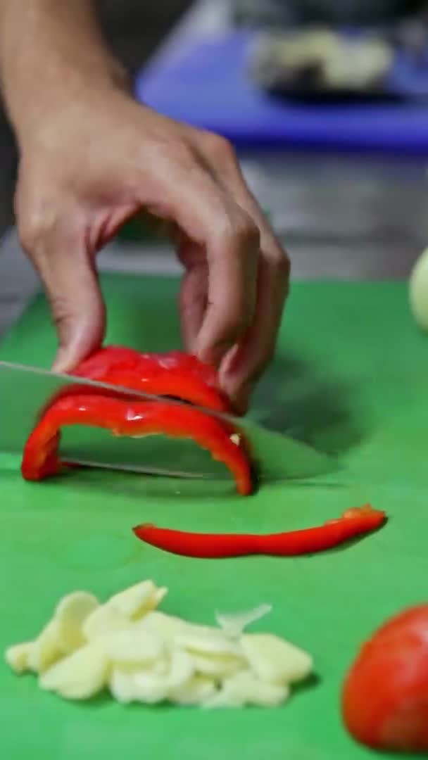 Le verdure fresche ecologiche sono tagliate a fette da un cuoco per cucinare, un'insalata vegetariana. Video verticale. — Video Stock