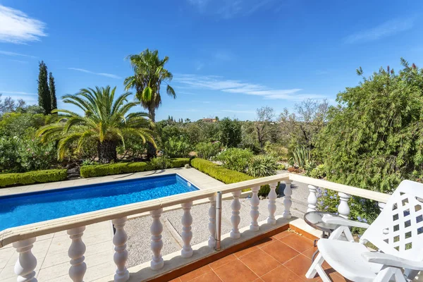 Uitzicht vanaf het terras naar het luxe zwembad met helder water in de tuin. Voor toeristen. — Stockfoto